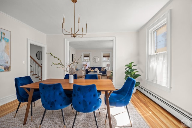 7 Mckinstry Pl, Hudson, NY 12534 - dining area featuring a baseboard radiator, a chandelier, wood finished floors, healthy amount of natural light, and ornamental molding