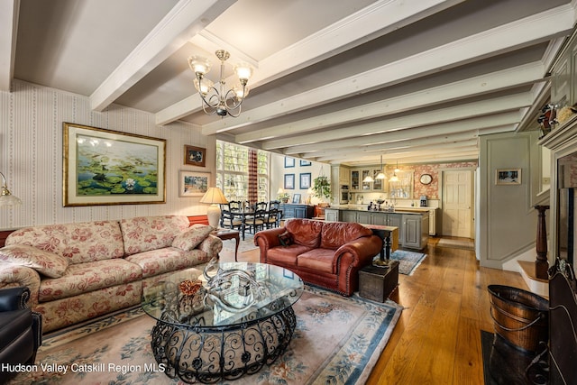 living room with crown molding, beamed ceiling, a chandelier, and hardwood / wood-style flooring