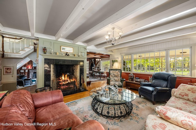 living room with wooden walls, beamed ceiling, wood-type flooring, and a notable chandelier