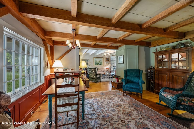 dining area featuring hardwood / wood-style flooring, lofted ceiling with beams, and a notable chandelier