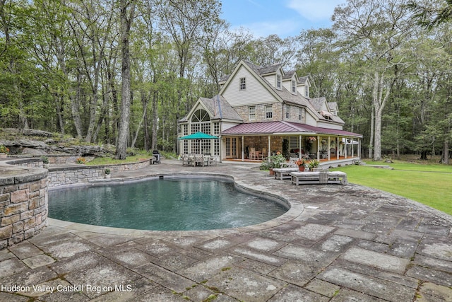 view of swimming pool featuring a lawn and a patio area