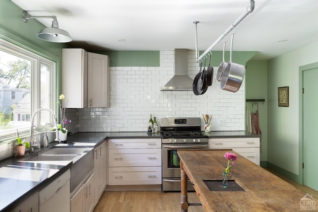 44 Worth Ave, Hudson, NY 12534 - kitchen featuring gas stove, wall chimney exhaust hood, a sink, and backsplash