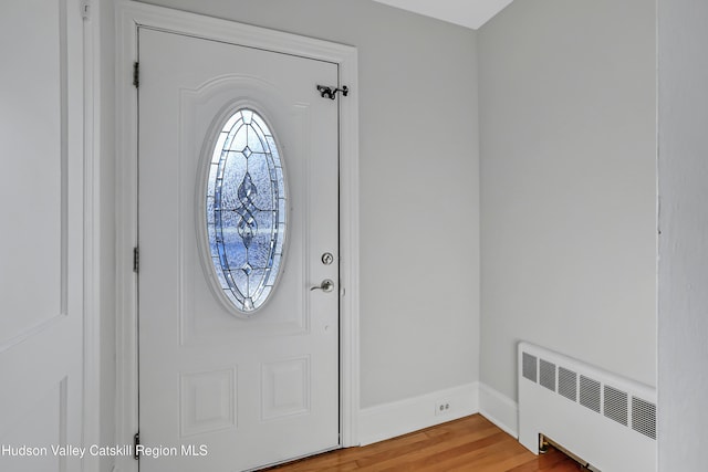 entryway with radiator heating unit and hardwood / wood-style floors