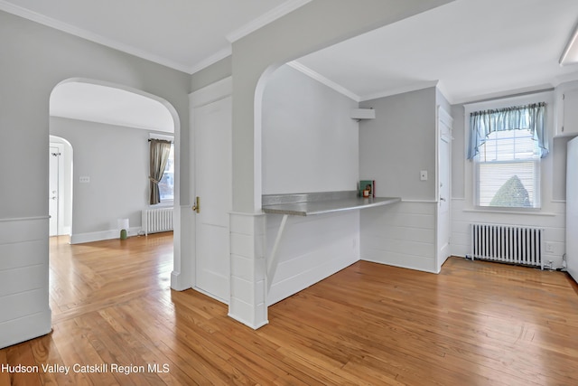 foyer entrance featuring radiator, crown molding, and light hardwood / wood-style flooring