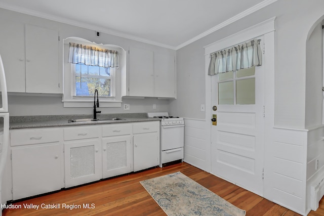 kitchen featuring white cabinets, sink, ornamental molding, light hardwood / wood-style floors, and white range oven