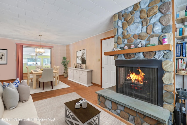 living room featuring light hardwood / wood-style floors and a stone fireplace