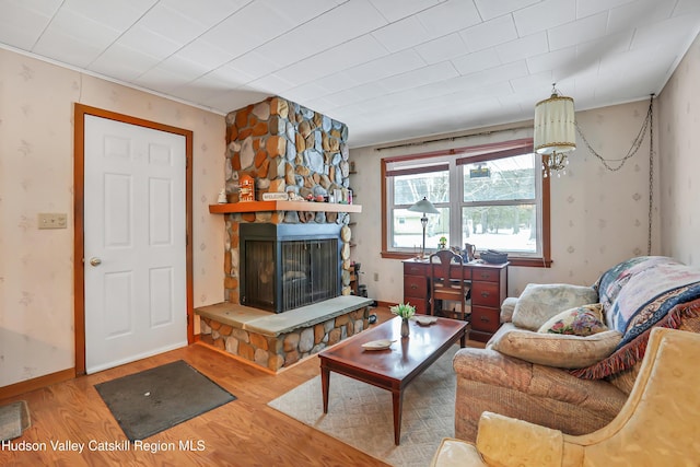 living room featuring wood-type flooring and a stone fireplace