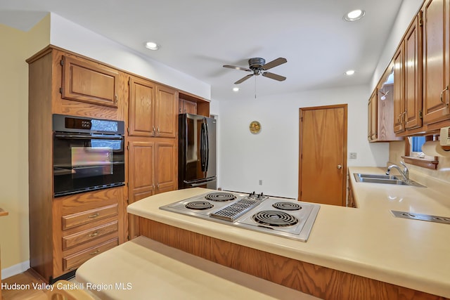 kitchen featuring black appliances, ceiling fan, sink, and kitchen peninsula