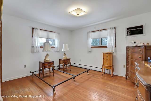 sitting room featuring baseboard heating and light hardwood / wood-style flooring