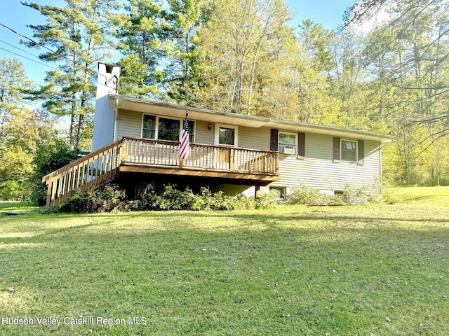 view of front of home featuring a wooden deck, cooling unit, and a front yard