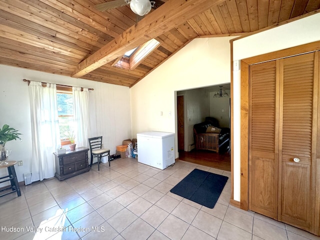 washroom with a skylight, ceiling fan, light tile patterned floors, and wood ceiling