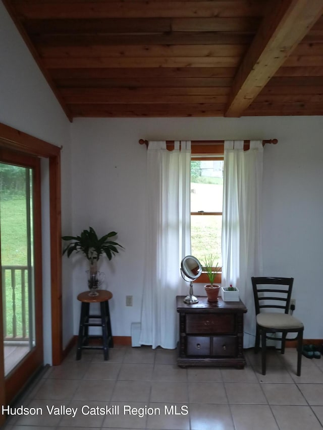 sitting room featuring lofted ceiling with beams, light tile patterned flooring, and wood ceiling