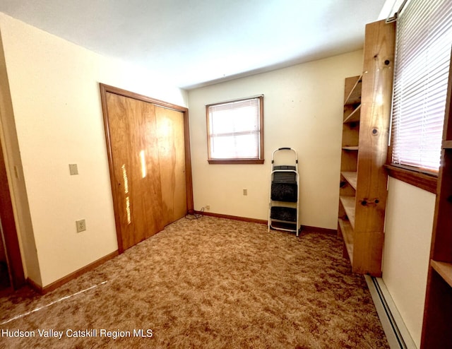 unfurnished bedroom with baseboard heating, a closet, and carpet