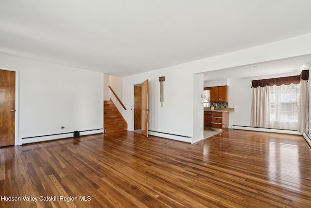4 Schuler Ln, Lake Katrine, NY 12449 - unfurnished living room featuring baseboard heating, wood finished floors, and stairs