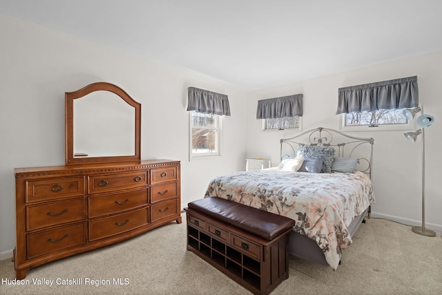 bedroom featuring multiple windows and light carpet