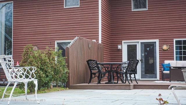 wooden terrace with outdoor dining area and a patio area