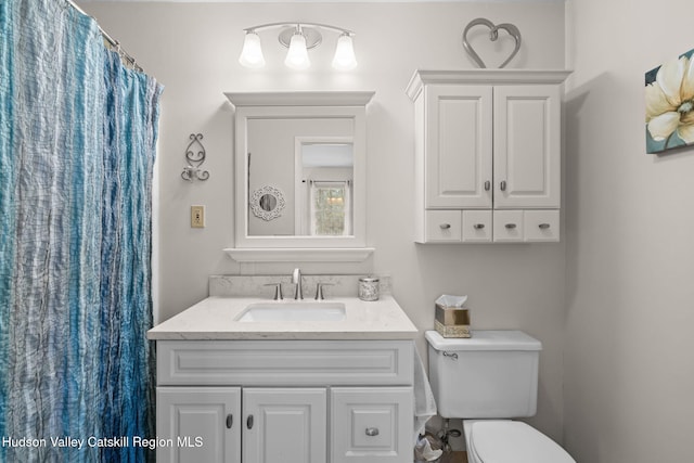 bathroom with vanity, curtained shower, and toilet