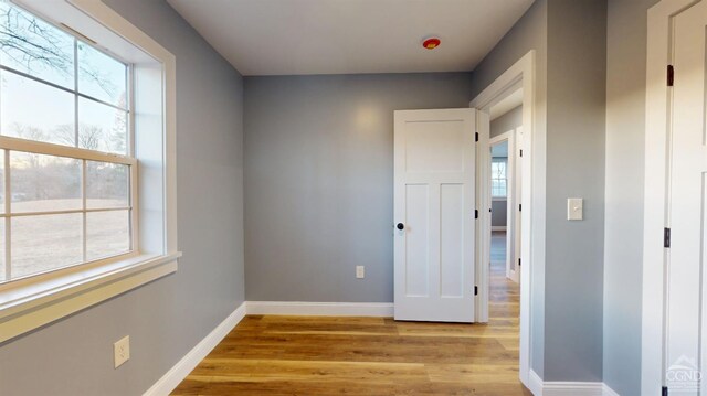 empty room featuring light wood-type flooring and baseboards
