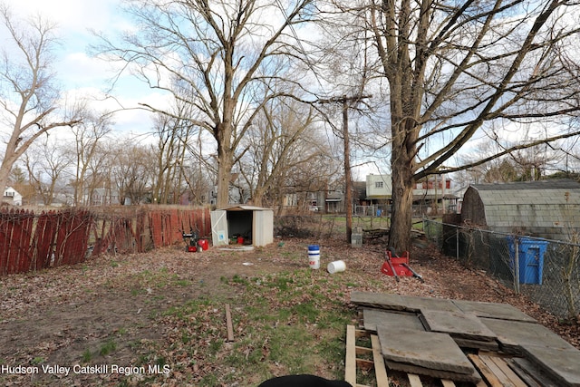 view of yard with an outbuilding, fence, and a shed
