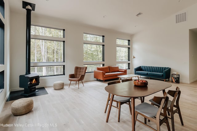 dining room with a wood stove and light hardwood / wood-style flooring