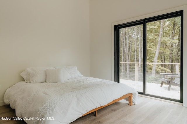 bedroom with light hardwood / wood-style floors and access to exterior