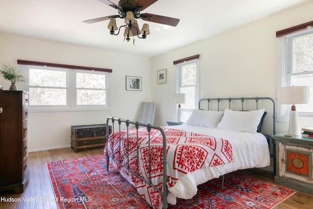 bedroom with wood-type flooring, baseboards, and ceiling fan