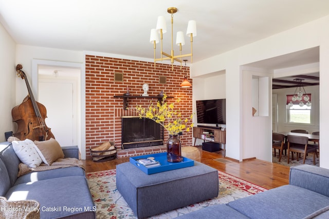 living area featuring wood finished floors, a chandelier, and a fireplace