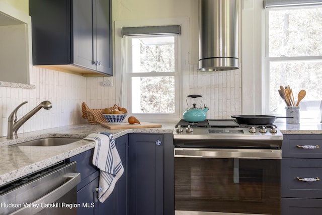 kitchen featuring appliances with stainless steel finishes, tasteful backsplash, blue cabinets, and a sink
