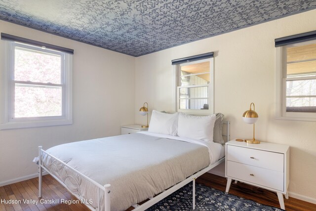 bedroom featuring wood finished floors and baseboards