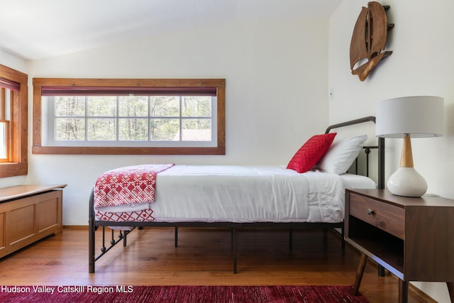 bedroom with lofted ceiling and wood finished floors
