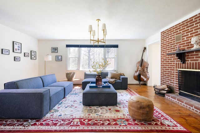 living room with wood finished floors, a fireplace, and a chandelier
