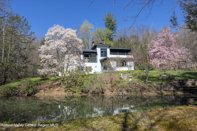 back of house featuring a chimney and a water view
