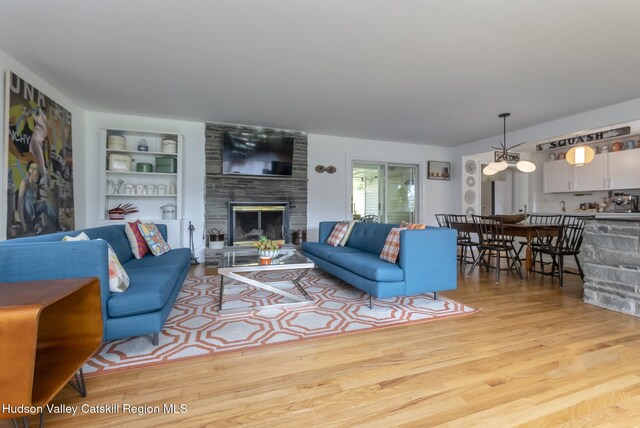 331 Joys Ln, Hurley, NY 12443 - living room featuring wood finished floors, a fireplace, and built in shelves