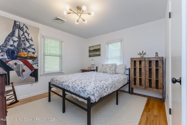 331 Joys Ln, Hurley, NY 12443 - bedroom with light wood finished floors, multiple windows, and a chandelier