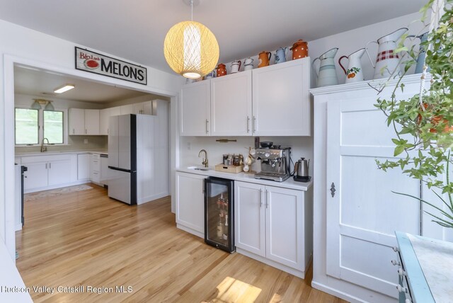 331 Joys Ln, Hurley, NY 12443 - kitchen featuring beverage cooler, freestanding refrigerator, light countertops, and white cabinetry