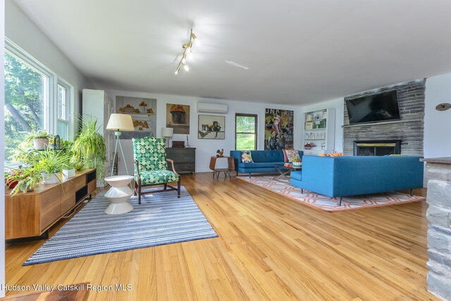 331 Joys Ln, Hurley, NY 12443 - living room with a fireplace, plenty of natural light, a wall mounted air conditioner, and wood finished floors