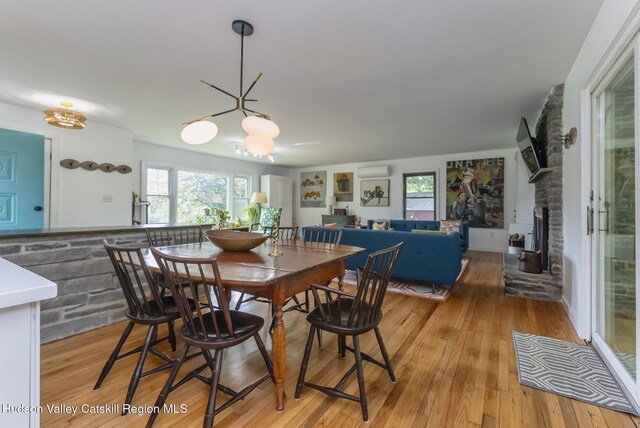 331 Joys Ln, Hurley, NY 12443 - dining room featuring a chandelier, plenty of natural light, light wood-type flooring, and a fireplace