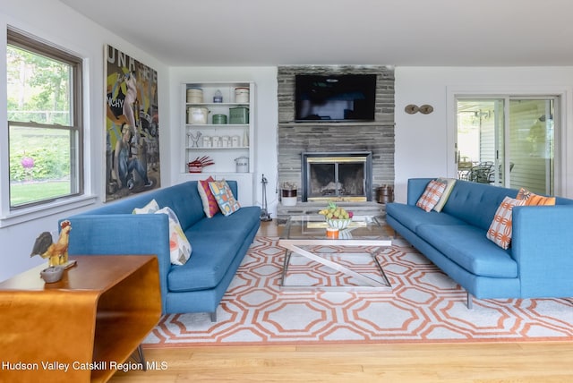 331 Joys Ln, Hurley, NY 12443 - living area featuring built in shelves, a stone fireplace, and wood finished floors