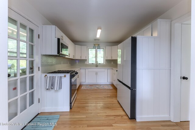 331 Joys Ln, Hurley, NY 12443 - kitchen with freestanding refrigerator, stainless steel microwave, gas stove, light wood-style flooring, and light countertops