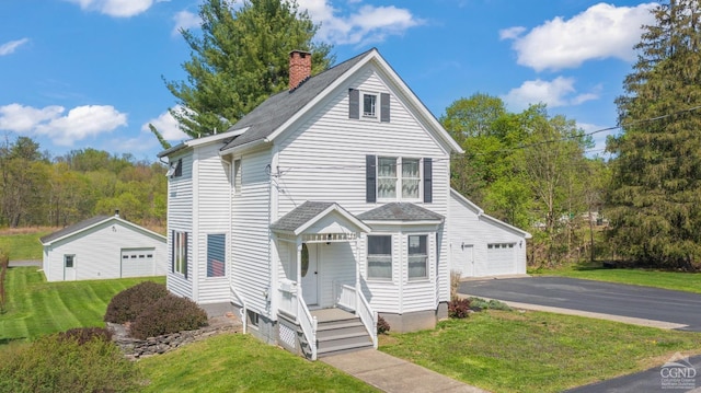 470 W Main St, Catskill, NY 12414 - traditional home featuring a garage, a chimney, asphalt driveway, roof with shingles, and a front lawn