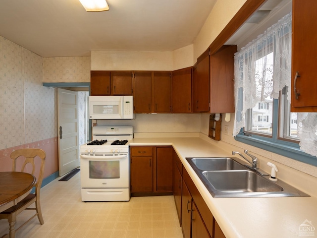 16 Oakwood Blvd, Hudson, NY 12534 - kitchen featuring white appliances, a sink, brown cabinetry, wallpapered walls, and light countertops