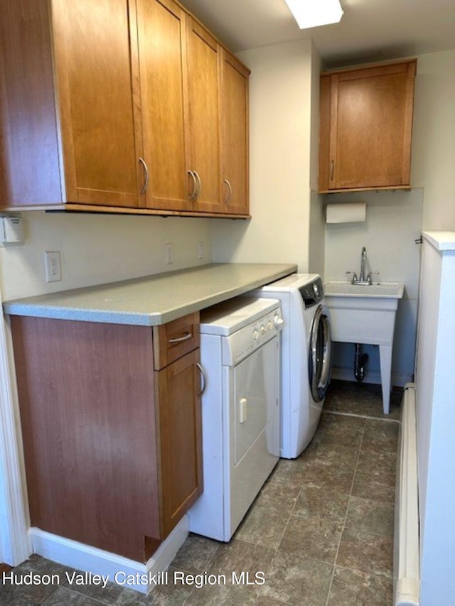 clothes washing area featuring cabinets and separate washer and dryer