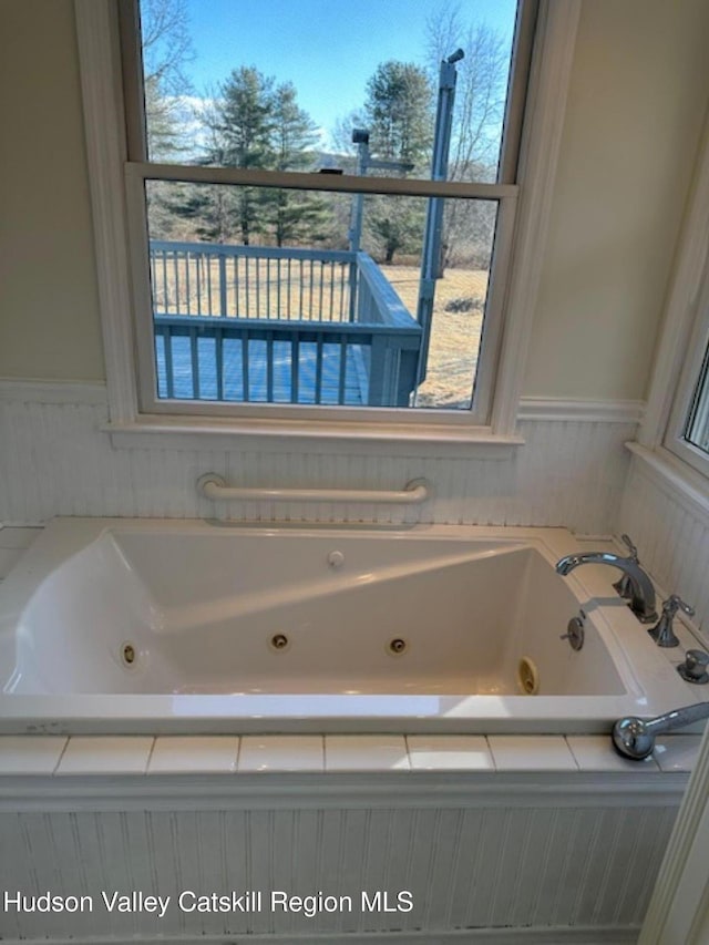 bathroom with tiled bath and plenty of natural light