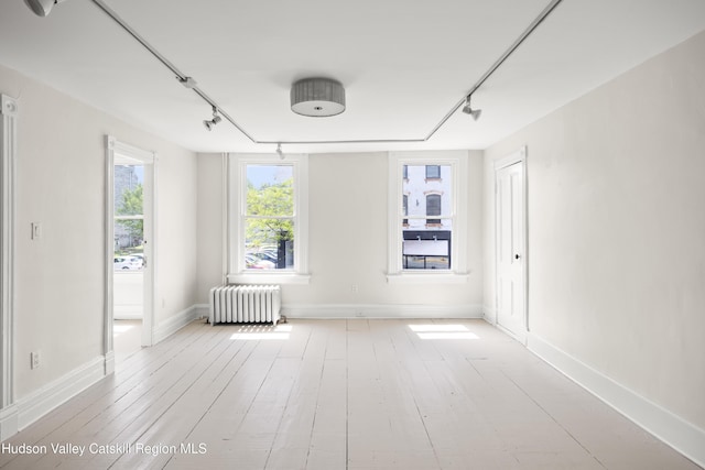 356 Warren St, Hudson, NY 12534 - unfurnished room featuring radiator heating unit, track lighting, and wood-type flooring