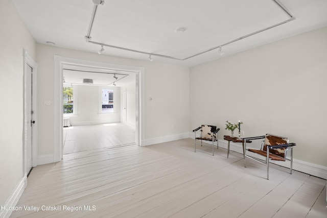 356 Warren St, Hudson, NY 12534 - living area with track lighting, wood finished floors, and radiator heating unit