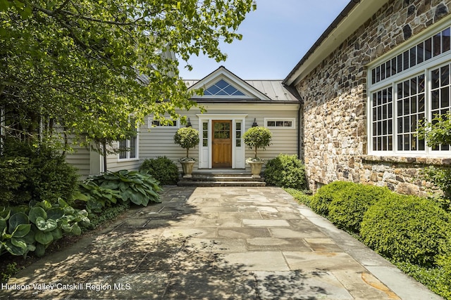 147 Moadock Rd, Millerton, NY 12546 - view of exterior entry featuring stone siding, a standing seam roof, and a metal roof