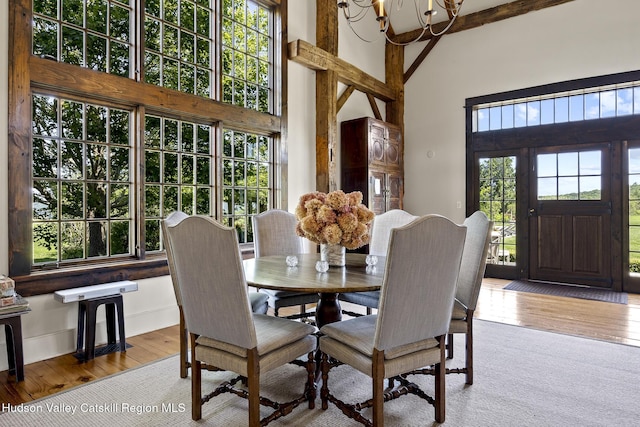 147 Moadock Rd, Millerton, NY 12546 - dining space featuring a towering ceiling, a chandelier, and hardwood / wood-style flooring