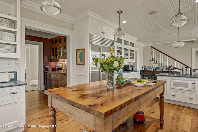 147 Moadock Rd, Millerton, NY 12546 - kitchen with built in appliances, white cabinets, butcher block countertops, ornamental molding, and glass insert cabinets