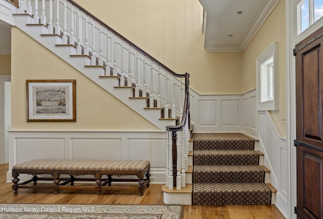 147 Moadock Rd, Millerton, NY 12546 - staircase with a decorative wall, crown molding, plenty of natural light, wood finished floors, and wainscoting