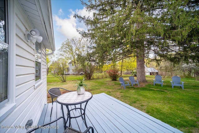 wooden terrace featuring a lawn